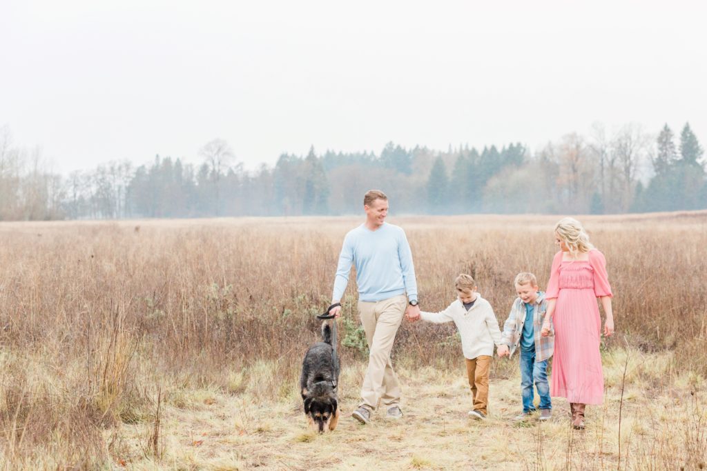 how to do family photos with dogs - family of four with dog in a field