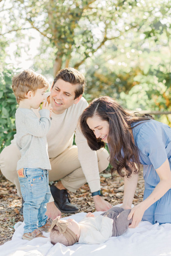 family of four in the orchard at luscher farm at the best time of day for outdoor photos with young children - 8am