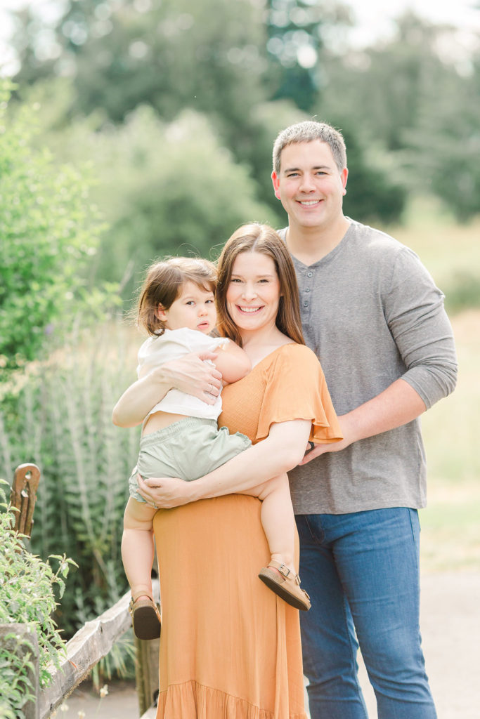 family of three poses at Luscher Farms Lake Oswego for a family photo session