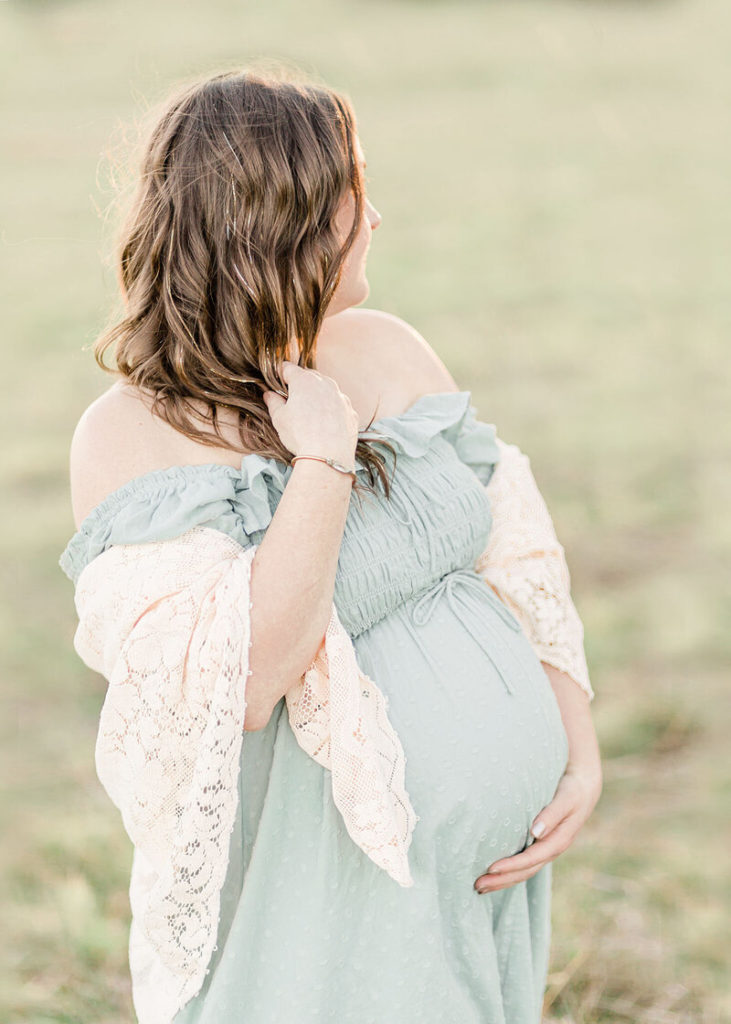 woman wearing a lace shawl and blue dress for maternity photos in winter