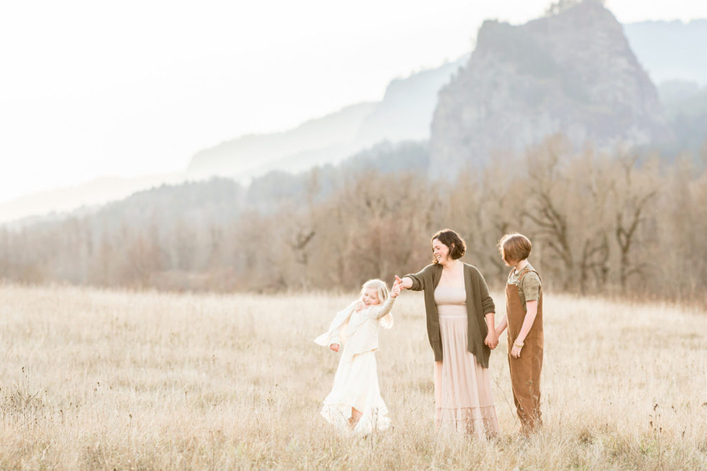 mom dances with her daughter in front of mountain view at the columbia river gorge