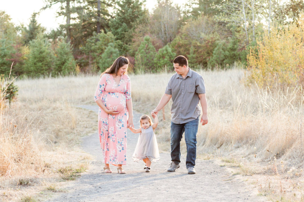 family of 3 walking in a field