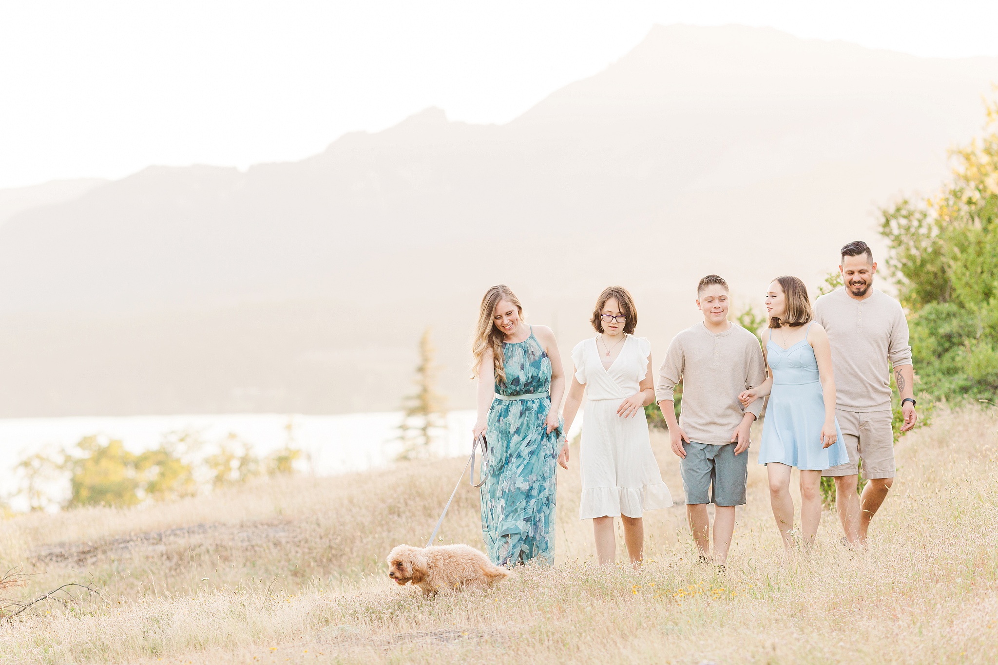 family photos with teens walking with dog in front of a mountain
