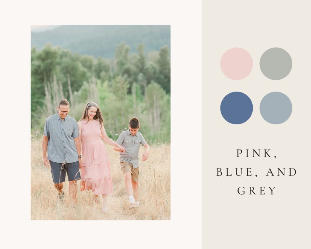 Family of three in pink, blue, and grey for family photo in a field
