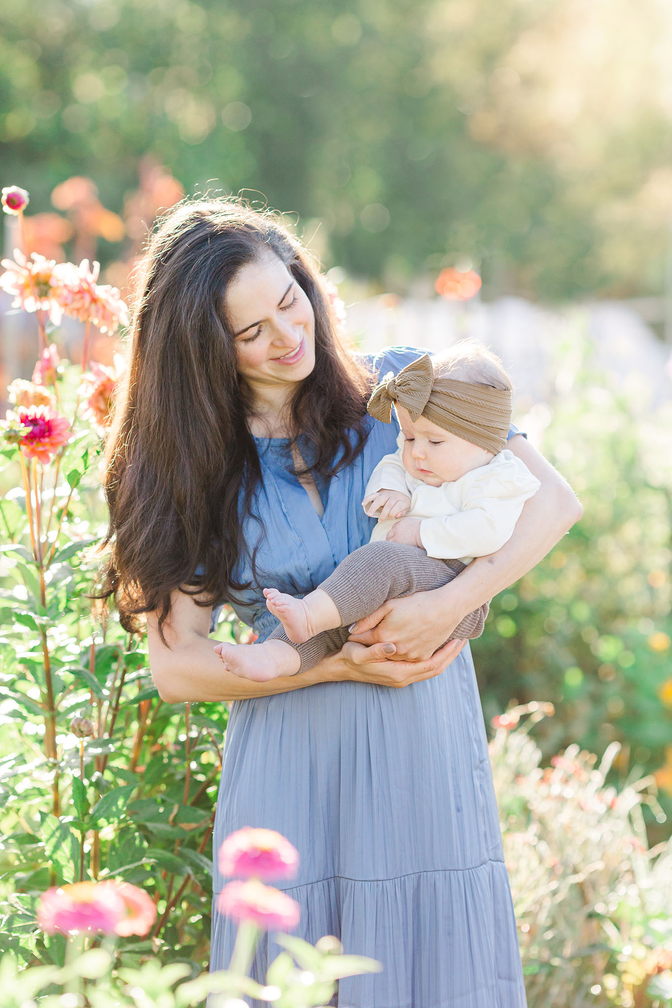 mom holding baby in a flower field at spring family picture location luscher farms lake oswego