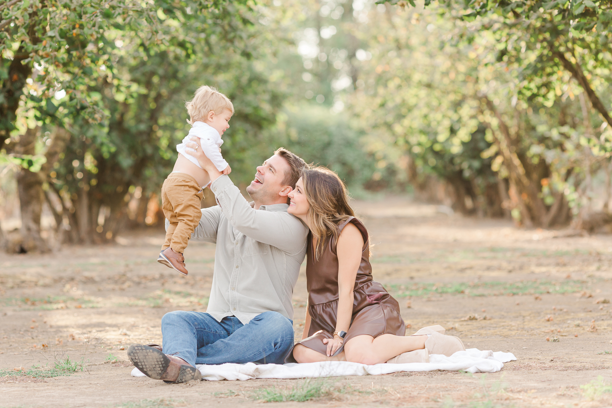 Family of three in an orchard at the best time of day for outdoor photos - 7pm