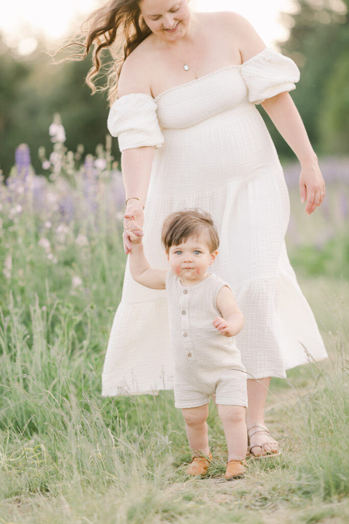 baby walking while holding mom's hand by pnw motherhood photographer Samantha Shannon
